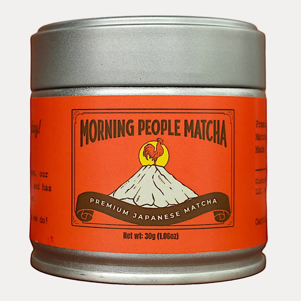 Canister of 'Morning People Matcha' with orange label and silver lid on white background